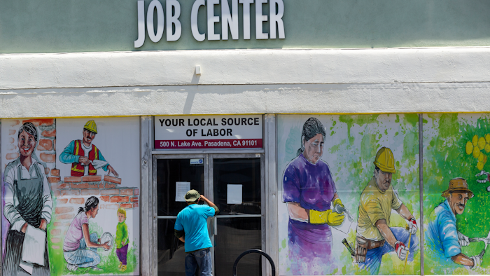 In this file photo, a person looks inside the closed doors of the Pasadena Community Job Center.