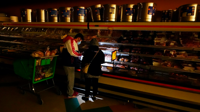 Texans shop in a dark supermarket after one of the worst blackouts in state history, February 2021.