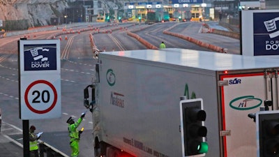 Trucks pass a checkpoint at the port in Dover, England, Dec. 31, 2020.