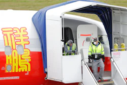 In this April 21, 2020, file photo, Boeing Co. workers wearing masks stand near an entry door to a 737 Max airplane owned by China-based Lucky Air, in Renton, Wash. China isn’t ready to join the United States in approving Boeing’s 737 Max to return to flying following a two-year grounding prompted by a pair of fatal crashes, a regulator said Monday, March 1, 2021.