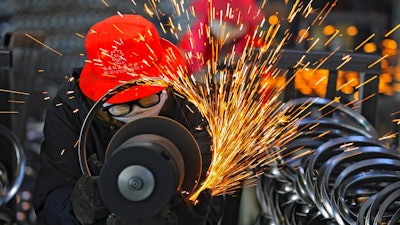 In this Feb. 19, 2021, file photo, workers wearing face masks polish bicycle wheel rims at a factory in Hangzhou in east China's Zhejiang province. China’s factory activity rebounded in March from a three-month slowdown as export orders rose, a survey showed Wednesday, March 31, 2021.