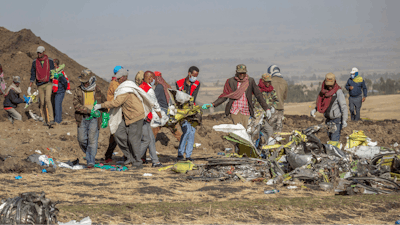 In this file photo, rescuers work at the scene of an Ethiopian Airlines flight crash near Bishoftu, or Debre Zeit, south of Addis Ababa, Ethiopia.