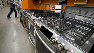 This Oct. 29, 2020 file photo, a passer-by walks past stoves on display at a Home Depot location, in Boston. Orders to U.S. factories for big-ticket goods shot up 3.4% in January 2021, pulled up by surge in orders for civilian aircraft. A category that tracks business investment posted a more modest gain, the Commerce Department reported Thursday, Feb. 24.