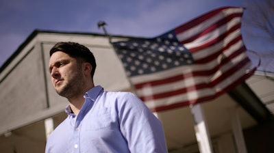 Logan DeWitt stands outside his home in Kansas City, Kansas.