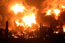 Cars pass by as fire razes through Pertamina Balongan Refinery in Indramayu, West Java, Indonesia, early Monday, March 29, 2021. Hundreds of people were evacuated from a nearby village after the massive fire broke out at the refinery.