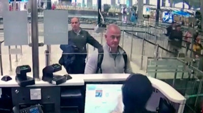 This image from security camera video shows Michael L. Taylor, center, and George-Antoine Zayek at passport control at Istanbul Airport in Turkey.