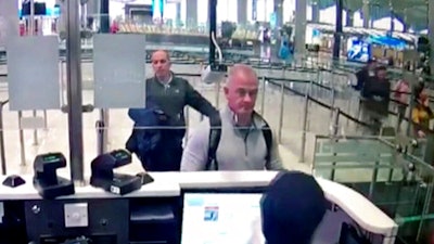 This Dec. 30, 2019, file image from security camera video shows Michael L. Taylor, center, and George-Antoine Zayek at passport control at Istanbul Airport in Turkey. Michael Taylor and his son Peter, suspected of helping former Nissan Chairman Carlos Ghosn skip bail and escape to Lebanon in December 2019 have been extradited to Japan. They were handed over to Japanese custody on Monday, March 1, 2021 and were due to arrive in Tokyo on Tuesday.