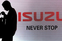In this file photo, a man walks past the Isuzu logo during the launch of Isuzu MU-X SUV in New Delhi, India.