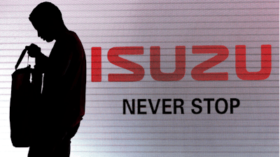 In this file photo, a man walks past the Isuzu logo during the launch of Isuzu MU-X SUV in New Delhi, India.