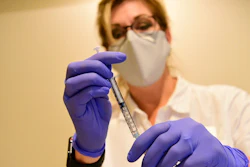 This file photo provided by Johnson & Johnson shows a pharmacist preparing to give an experimental COVID-19 vaccine.