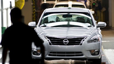 In this May 15, 2012, file photo, a worker walks by a new Nissan Altima on the line after the company celebrated the start of production of the fifth generation of the model at the plant in Smyrna, Tenn. A union wants to hold a vote for representation of fewer than 100 out of thousands of workers at the Nissan vehicle assembly plant in Tennessee, a move the company opposes because the effort doesn't stretch more broadly across the facility's workforce. The National Labor Relations Board began hearing arguments Friday, March 12, 2021, in a case over whether a vote can be held for the subset of employees.