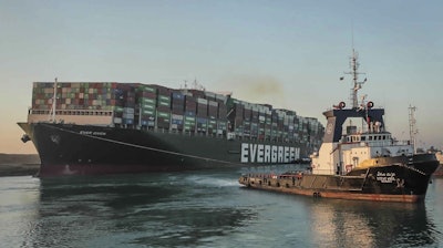 In this photo released by Suez Canal Authority, the Ever Given, a Panama-flagged cargo ship, is pulled by one of the Suez Canal tugboats.