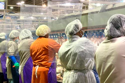 Tyson Foods workers wear protective masks and stand between plastic dividers at the company's Camilla, Georgia poultry processing plant.