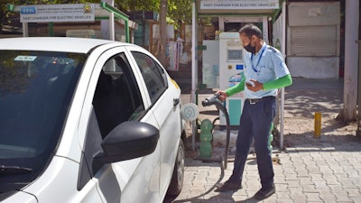 A driver of an electric car charges his vehicle at public charging station in New Delhi, April 1, 2021.