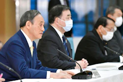 Japanese Prime Minister Yoshihide Suga, left, at a cabinet meeting at his official residence in Tokyo, April 12, 2021.