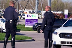 Police stand near the scene where multiple people were shot at the FedEx Ground facility early Friday morning in Indianapolis.