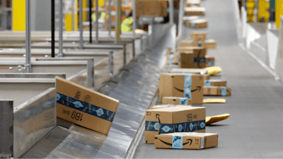 In this file photo, Amazon packages move along a conveyor at an Amazon warehouse facility in Goodyear, Arizona.