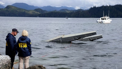 In this photo provided by the National Transportation Safety Board, NTSB investigator Clint Crookshanks, left, and member Jennifer Homendy stand near the site of some the wreckage.