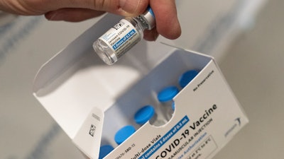 In this file photo, a pharmacist holds a vial of the Johnson & Johnson COVID-19 vaccine.