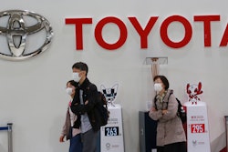 In this file photo, visitors walk at a Toyota showroom in Tokyo.