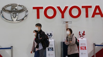 In this file photo, visitors walk at a Toyota showroom in Tokyo.