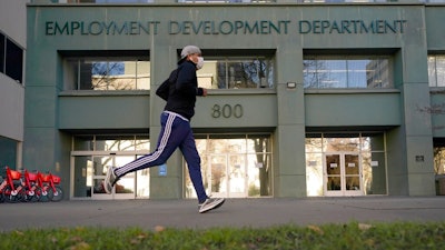 In his Dec. 18, 2020, file photo a runner passes the office of the California Employment Development Department in Sacramento, Calif. California lawmakers on Thursday, April 8, 2021, advanced what they called commonsense legislation requiring two state agencies to share information aimed at helping stop billions of dollars in pandemic-related unemployment fraud.