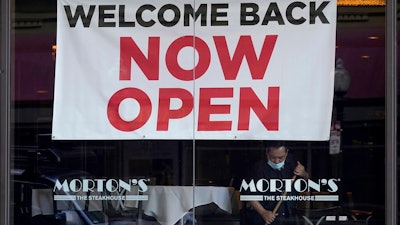 In this March 4, 2021, file photo, a sign reading 'Welcome Back Now Open' is posted on the window of a Morton's Steakhouse restaurant as a man works inside during the coronavirus pandemic in San Francisco. California added 141,000 jobs in February as more than a quarter of a million people returned to the workforce. The California Employment Development Department said Friday, March 26, that the state's unemployment rate in February was 8.5%, down from 9% in January.