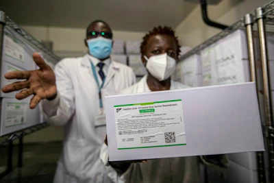 Technicians in Nairobi, Kenya, hold a carton of AstraZeneca COVID-19 vaccine manufactured in India.