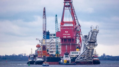 Tugboats get into position on the Russian pipe-laying vessel 'Fortuna' in the port of Wismar, Germany, Jan. 14, 2021.