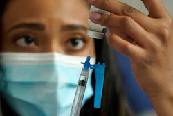 Licensed practical nurse Yokasta Castro draws a Moderna COVID-19 vaccine into a syringe at a mass vaccination clinic, Gillette Stadium, Foxborough, Mass., May 19, 2021.