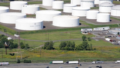 In this Sept. 8, 2008 file photo traffic on I-95 passes oil storage tanks owned by the Colonial Pipeline Company in Linden, N.J. A major pipeline that transports fuels along the East Coast says it had to stop operations because it was the victim of a cyberattack. Colonial Pipeline said in a statement late Friday that it “took certain systems offline to contain the threat, which has temporarily halted all pipeline operations, and affected some of our IT systems.”