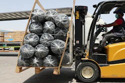 A forklift driver loads material for temporary shelters to be sent to India.