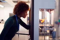 Female College Student Studying Engineering Using 3 D Printing Machine 1218975926 2125x1416