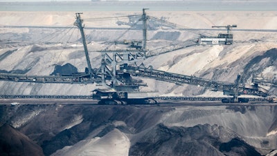 In this Thursday, April 29, 2021 file photo, giant bucket-wheel excavators extract coal at the controversial Garzweiler surface coal mine near Jackerath, west Germany. A report by the International Energy Agency on Tuesday, May 18, 2021 says immediate action is needed to reshape the world’s energy sector in order to meet ambitious climate goals by 2050. This includes ending investments in new coal mines, oil and gas wells.