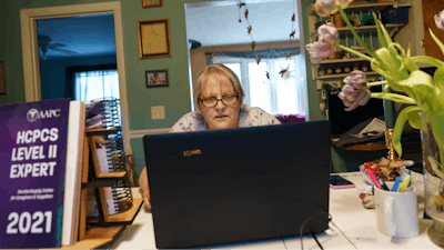 Ellen Booth, 57, studies at her kitchen table to become a certified medical coder in Coventry, RI.