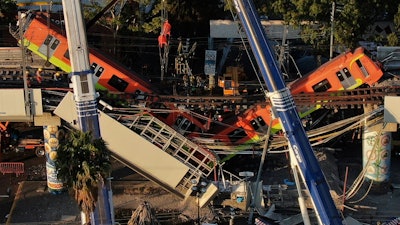 Subway cars dangle at an angle from a collapsed elevated section of the metro Number 12 Line, in Mexico City, Tuesday, May 4, 2021.