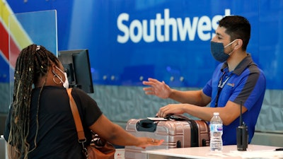 In this file photo a Southwest Airlines employee assists a passenger at the ticket counter.