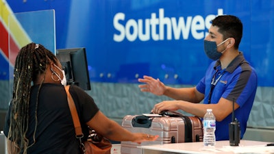 In this file photo a Southwest Airlines employee assists a passenger at the ticket counter.