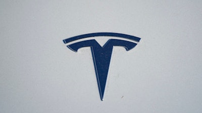 in this Sunday, Jan. 24, 2021, file photo, the company logo shines off the hood of an unsold 2021 Model 3 sedan at a Tesla dealership, in Littleton, Colo. Two key groups that offer automobile safety ratings have yanked their top endorsements of some Tesla vehicles because the company has stopped using radar on its safety systems.