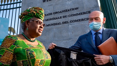 In this Monday, March 1, 2021 file photo, New Director-General of the World Trade Organisation Ngozi Okonjo-Iweala, left, walks at the entrance of the WTO.