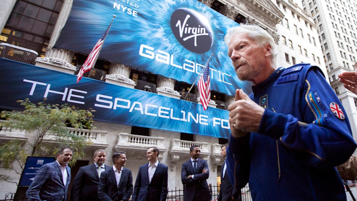 In this Monday, Oct. 28, 2019 file photo, Richard Branson, right, founder of Virgin Galactic, and company executives gather for photos outside the New York Stock Exchange before his company's IPO. In an interview after the Wednesday, June 30, 2021 satellite launch by his separate company Virgin Orbit, Branson said that he has to be “so circumspect” in what he says about Virgin Galactic. “All I can say is when the engineers tell me that I can go to space, I’m ready, fit and healthy to go. So we’ll see,” he said.