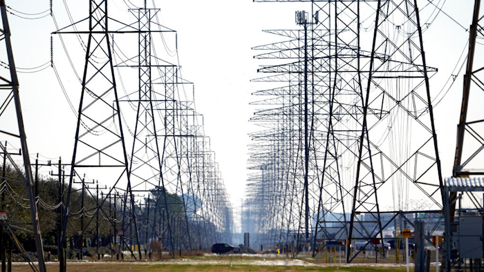 This Tuesday, Feb. 16, 2021 file photo shows power lines in Houston. The electric power grid manager for most of Texas has issued its first conservation alert of the summer, calling on users to dial back energy consumption to avert an emergency. The Energy Reliability Council of Texas issued the alert shortly after midday Monday, saying many forced generation outages and potential record June demand is squeezing the power supply.