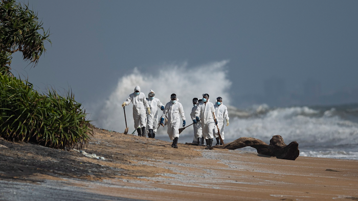 Sri Lankan navy soldiers collect debris that washed ashore from burning ship MV X-Press Pearl anchored off Colombo port at Kapungoda, out skirts of Colombo, Sri Lanka, Monday, May 31, 2021. The fire on the Singapore-flagged ship has been burning since May 20, ravaging the ship. Debris from the burning ship that has washed ashore is causing severe pollution on beaches.