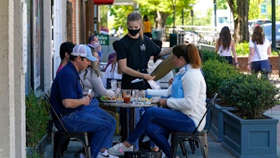 Patrons are assisted while dining along a sidewalk on Franklin Street in Chapel Hill, N.C. on April 16.