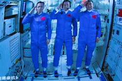 Chinese astronauts salute after successfully entering the Tianhe space station module as seen on a screen at the Beijing Aerospace Control Center, June 17, 2021.