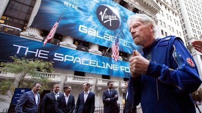In this Monday, Oct. 28, 2019 file photo, Richard Branson, right, founder of Virgin Galactic, and company executives gather for photos outside the New York Stock Exchange before his company's IPO. In an interview after the Wednesday, June 30, 2021 satellite launch by his separate company Virgin Orbit, Branson said that he has to be “so circumspect” in what he says about Virgin Galactic. “All I can say is when the engineers tell me that I can go to space, I’m ready, fit and healthy to go. So we’ll see,” he said.