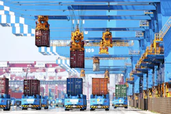 Gantry cranes move containers onto transporters at a port in Qingdao, China, June 4, 2021.