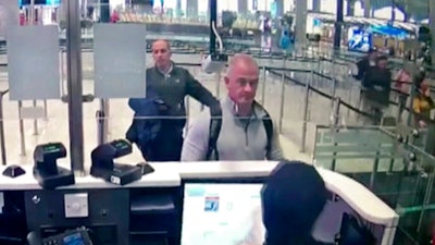 This Dec. 30, 2019 image from security camera video shows Michael L. Taylor, center, and George-Antoine Zayek at passport control at Istanbul Airport in Turkey. Americans Michael Taylor and his son Peter Taylor go on trial in Tokyo on Monday, June 14, 2021, on suspicion they helped Nissan former Chairman Carlos Ghosn skip bail in Japan and escape to Lebanon in December 2019.