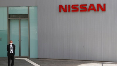 A man stands at Nissan Motor Co.'s global headquarters in Yokohama, near Tokyo, Tuesday, June 22, 2021. Nissan Chief Executive Makoto Uchida pleaded for patience from disgruntled shareholders Tuesday, promising a turnaround at the Japanese automaker, which is projecting a third year of losses as it struggles to distance itself from a scandal over its former Chairman Carlos Ghosn.
