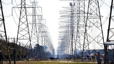 This Tuesday, Feb. 16, 2021 file photo shows power lines in Houston. The electric power grid manager for most of Texas has issued its first conservation alert of the summer, calling on users to dial back energy consumption to avert an emergency. The Energy Reliability Council of Texas issued the alert shortly after midday Monday, saying many forced generation outages and potential record June demand is squeezing the power supply.